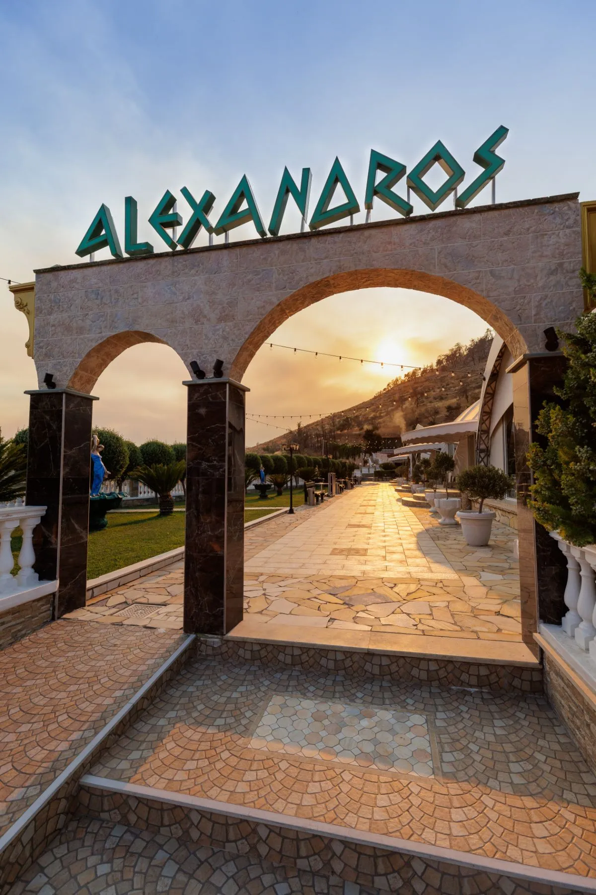 Η είσοδος «Αλέξανδρος» με τις πέτρινες αψίδες στο ηλιοβασίλεμα